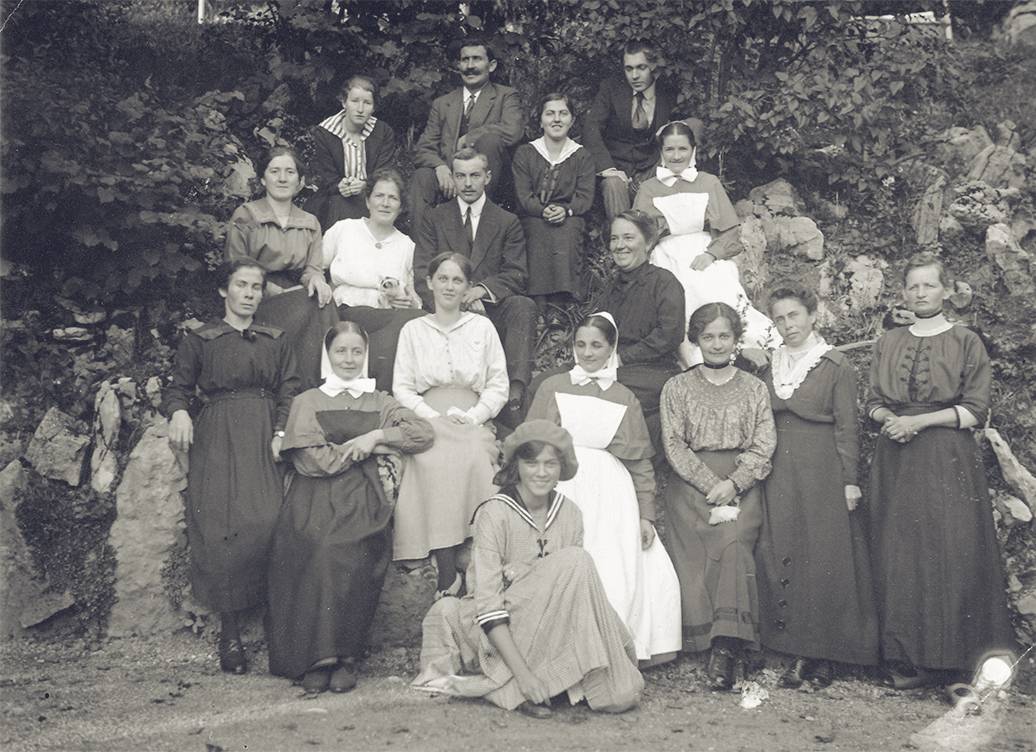 Adrienne von Speyr kneeling in front of a group of patients and nurses at the sanatorium of Langenbruck, Switzerland (1918)
